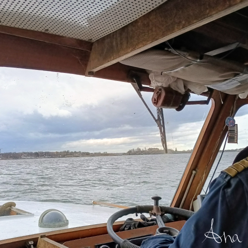 Skipper at the helm of an old boat